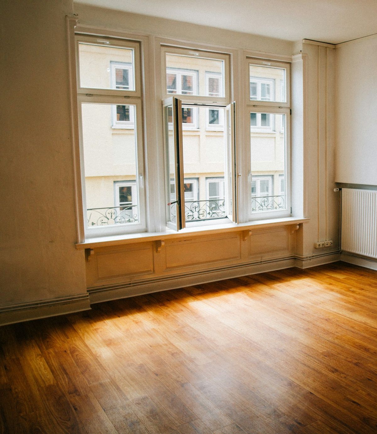 Pièce entièrement vidée et lumineuse, fenêtre ouverte, parquet propre